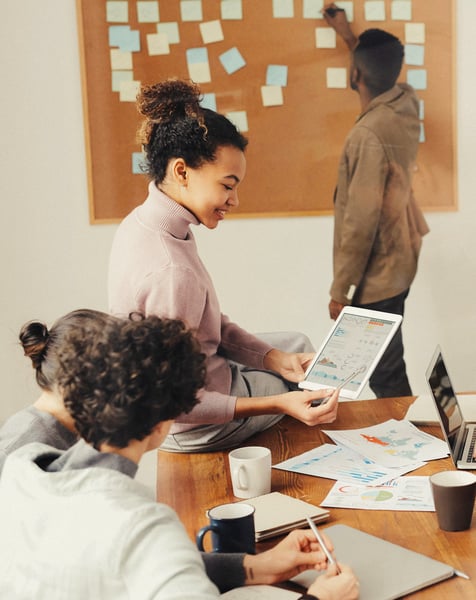 Personnes affichant des post-its sur un tableau et travaillant ensemble ©Pexels