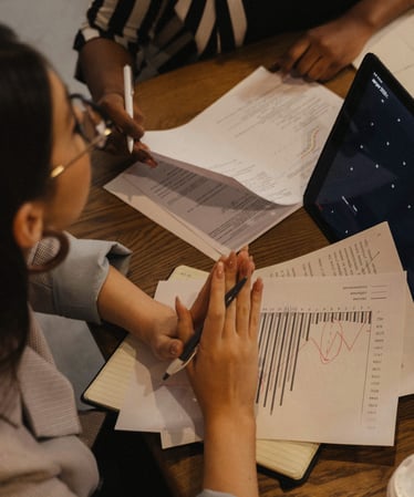 Personne avec des feuilles de papier et un ordinateur sur un bureau - ©Pexels Tima Miroshnichenko